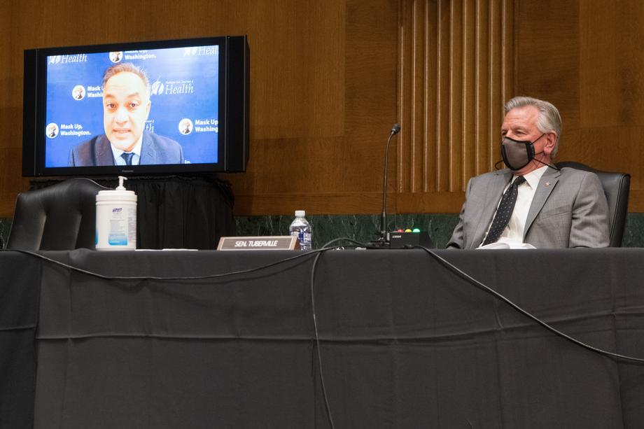 Senator Tuberville sitting at a table in a mask with Dr. Shah on the screen behind him.
