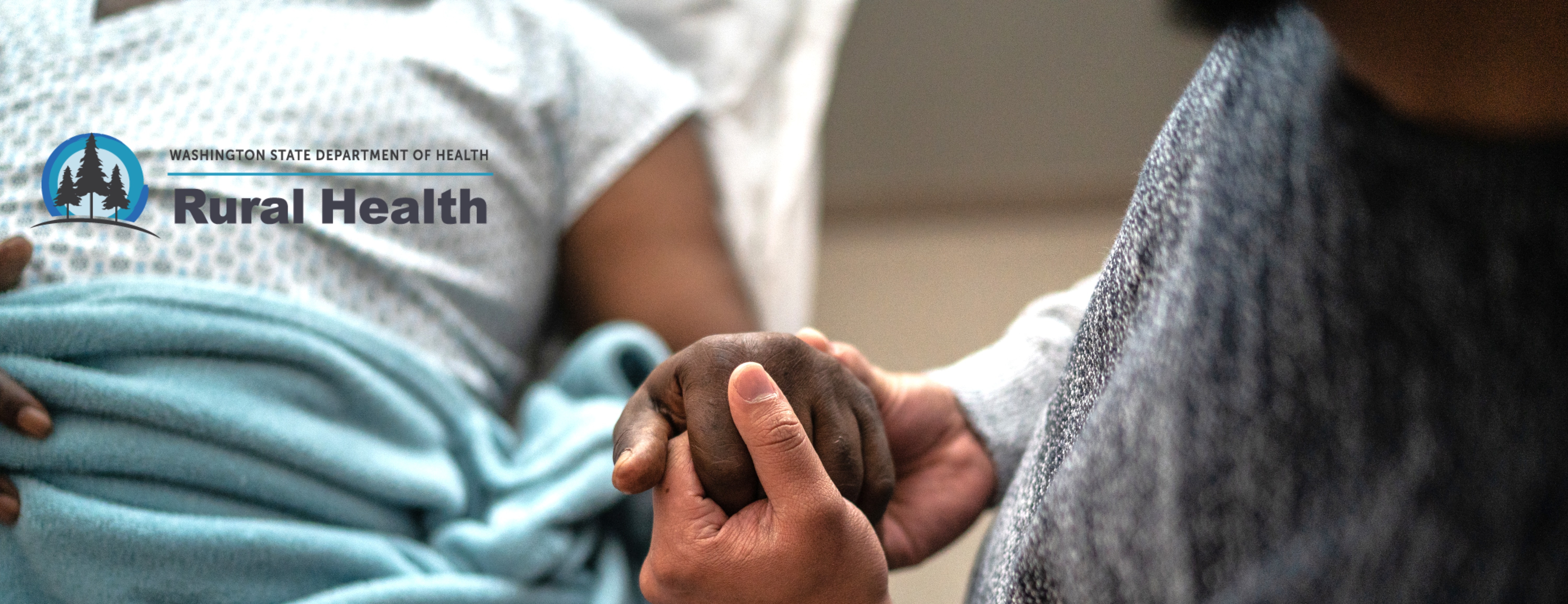 Father holding son's hand in hospital bed