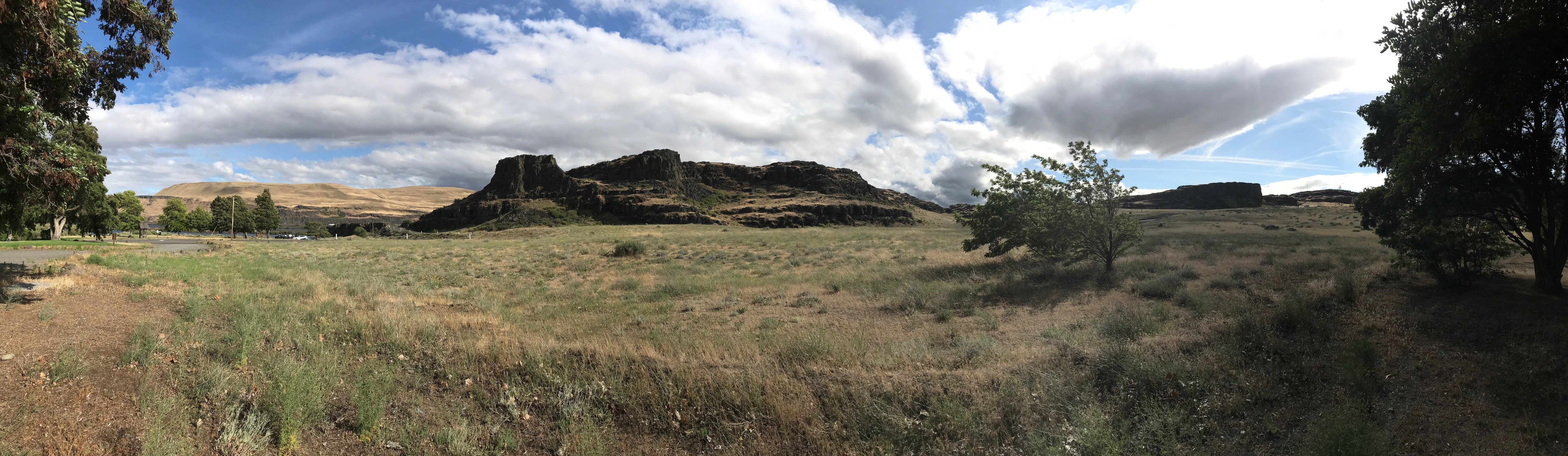 Breathtaking landscape view of Washington state Columbia Hills with mountains and large white clouds and blue skies.