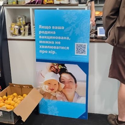 Ukrainian measles prevention display in Eastern European grocery store.
