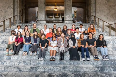 Members of the youth advisory council sit on the steps of the Washington State Capitol building.