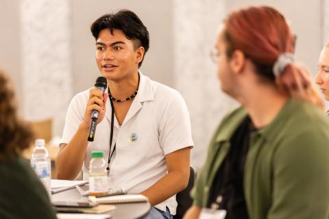 YAC member shares his perspective through a microphone.