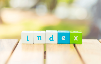 Lettered cubes on the edge of a table spelling out the word index.