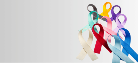 Stock photo of different colored cancer awareness ribbons on a gray background. 