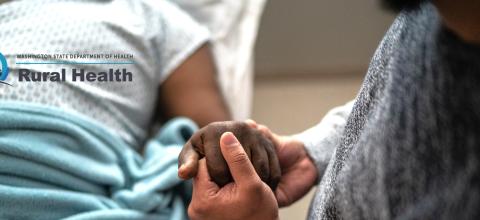 Father holding son's hand in hospital bed